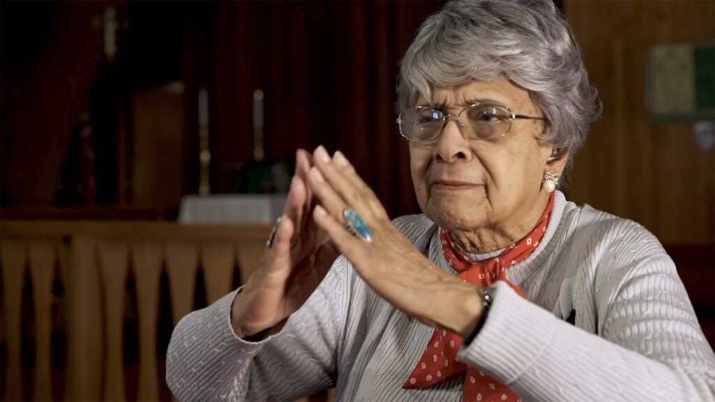 storyteller uses hands to imitate prayer and chapel architecture