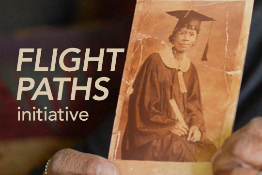 hands holding archival photograph of African American woman in cap and gown