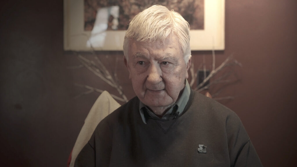 white haired man in sweater