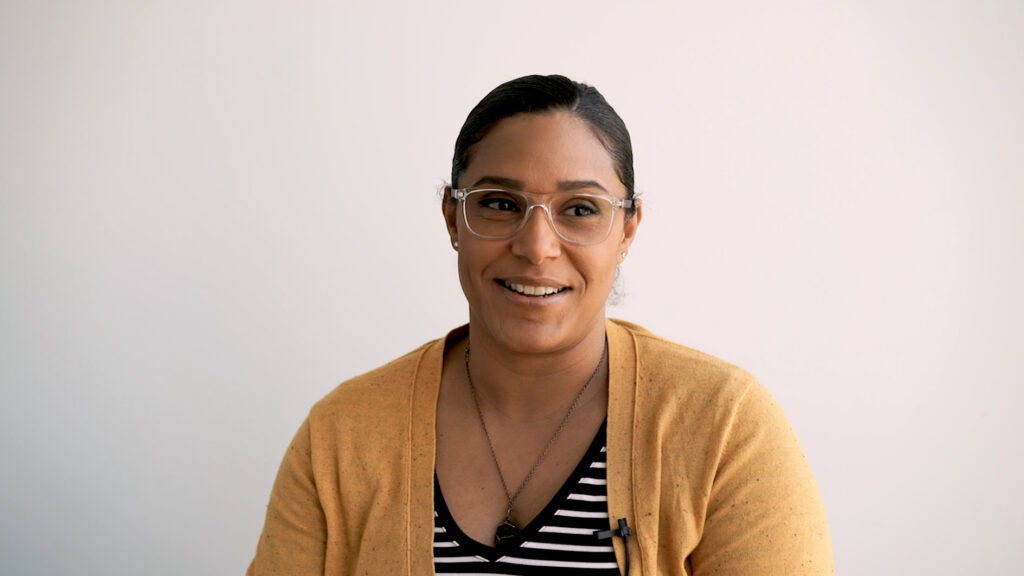 smiling woman with glasses and yellow cardigan