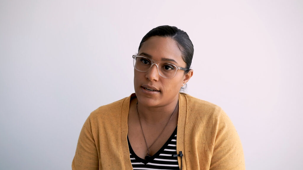 Woman in yellow cardigan looks intently