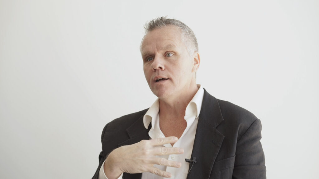 middle-aged man in blazer speaking