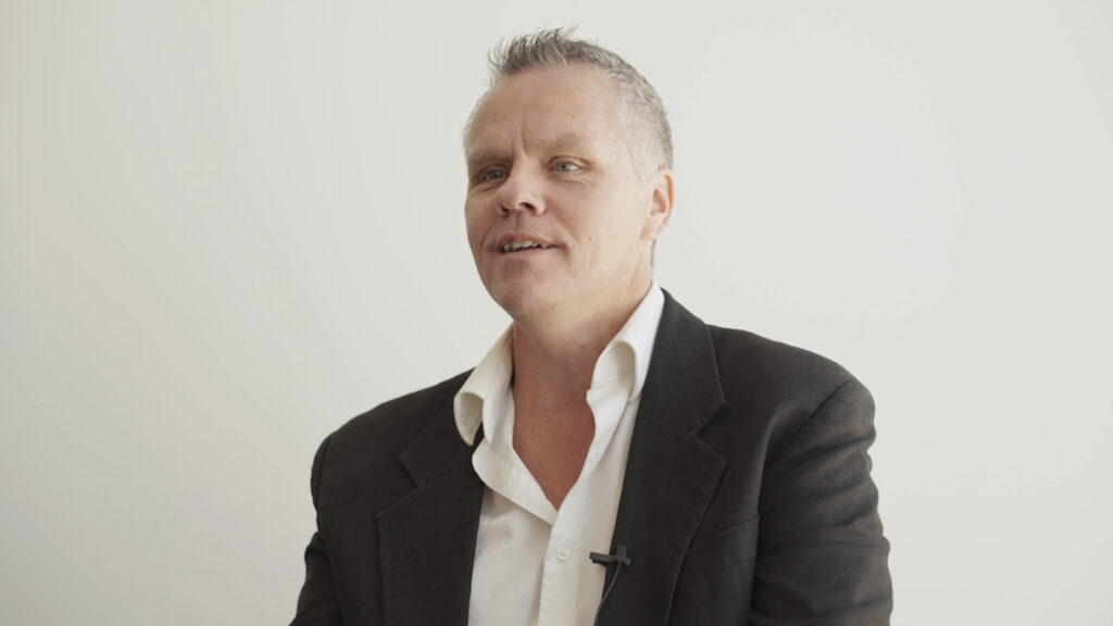 Man with close-cropped hair and sports jacket