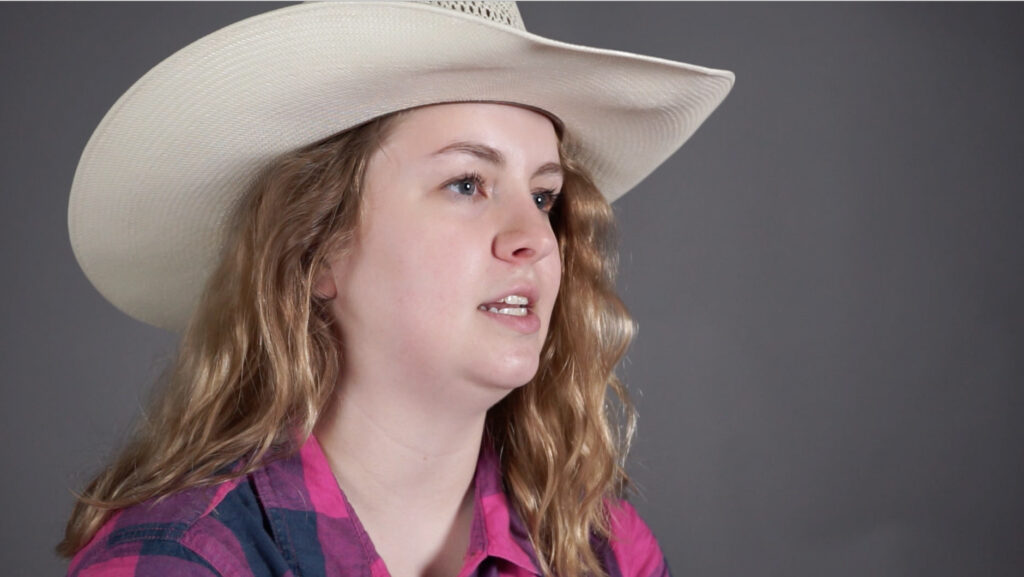 young woman with long hair wearing a cowboy hat