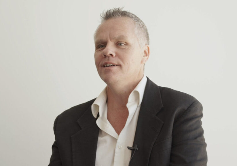 Man with close-cropped hair and sports jacket