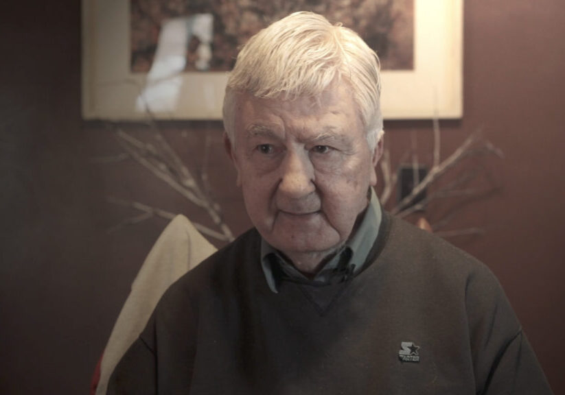 white haired man in sweater