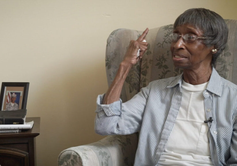 older woman pointing with raised hand