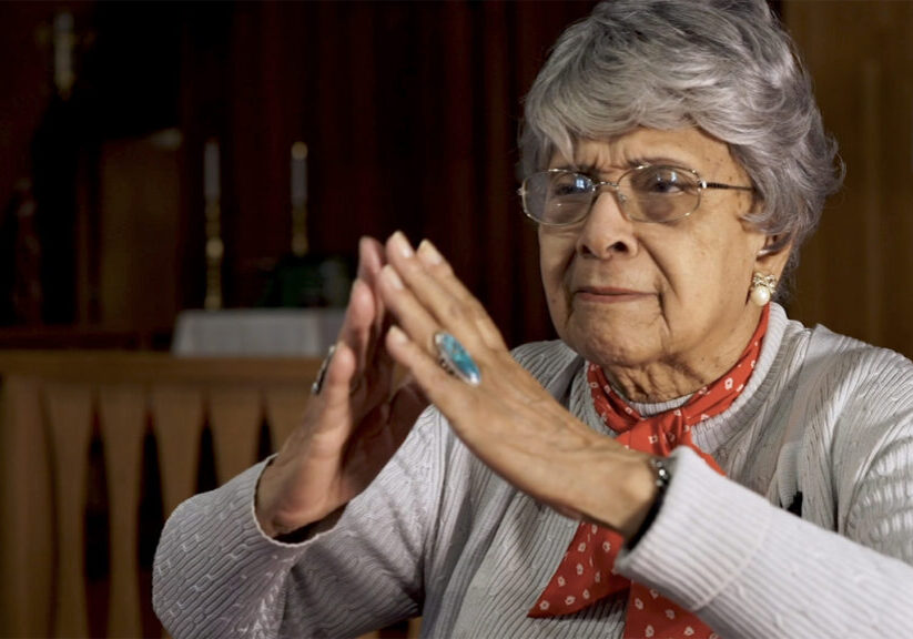 storyteller uses hands to imitate prayer and chapel architecture