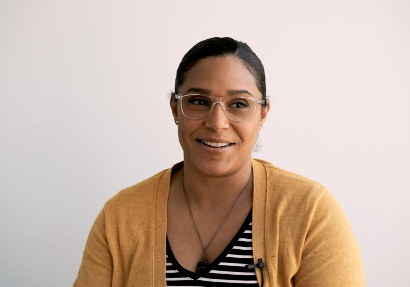 smiling woman with glasses and yellow cardigan