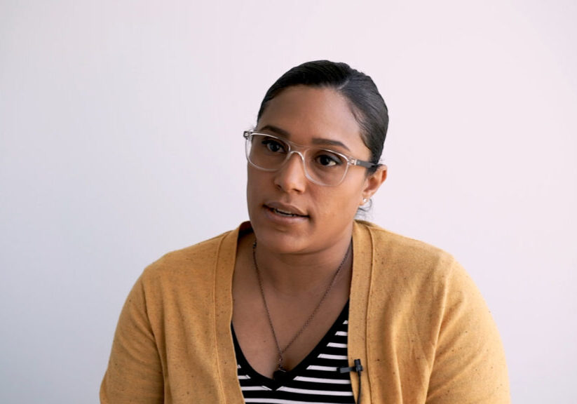 Woman in yellow cardigan looks intently